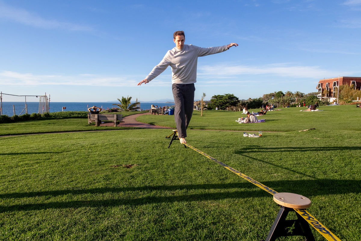 Man walking the SlackYard in a sunny backyard