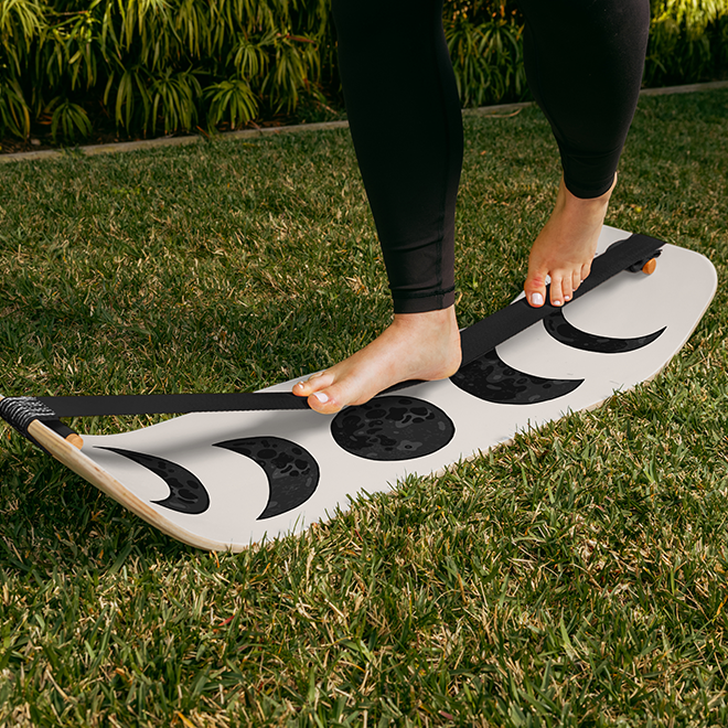 Person standing on a moon slackboard on grass
