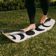 Person standing on a moon slackboard on grass
