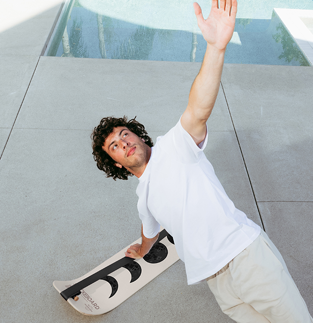 Man doing a side plank using a moon slackboard poolside