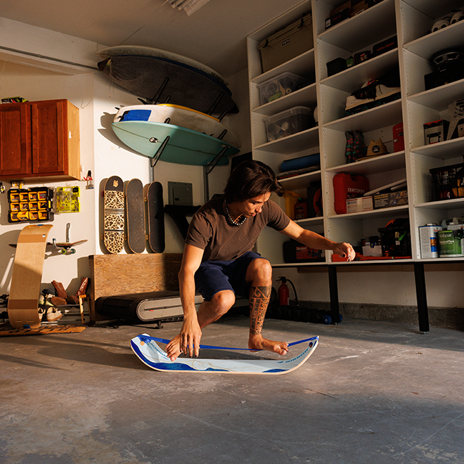 Person balancing on a mountain slackboard in a garage with shelves and tools in the background